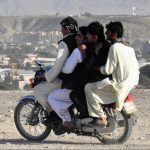 Image of three men on a motorcycle