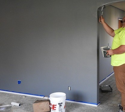 photo of a man painting in a home